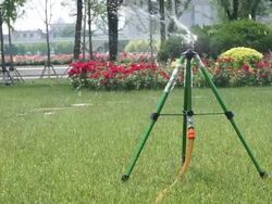 springkler watering park lawn at daytime Stock Footage