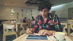 Young man using tablet pc and credit card inside coffee shop. Stock Footage