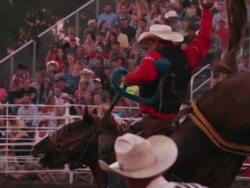 A cowboy on a bucking bronco is released from the chute at a rodeo - shot in slow motion. Stock Footage