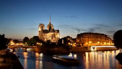 Boats pass by Notre Dame Cathedral along the Seine River. Stock Footage