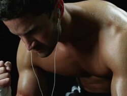MS TU Semi dressed athlete sitting and flexing arm muscles in studio Stock Footage