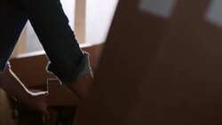 Shop worker seals cardboard box for shipping Stock Footage
