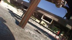 A steel arm ascends through  concrete, spraying water on the camera. Stock Footage