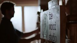 Shop owner hangs price tags on new skateboards by The Wood Studio sign Stock Footage