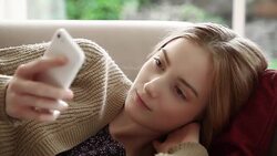 Sofa text message, pretty girl. Stock Footage