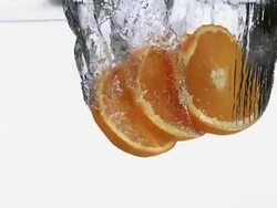 MS SLO MO Slices of orange entering into water against white background / Vieux Pont, Normandy, France  Stock Footage