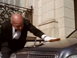 Low angle medium shot chauffeur polishing hood of limousine Stock Footage