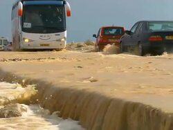 MS Cars driving through flooded desert road after Flash flood / Ein Gedi , Judean Desert , israel Stock Footage
