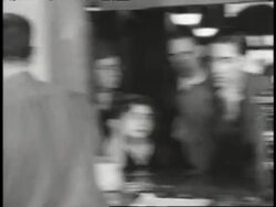 A postal worker weighs a package for a waiting customer. News Clip