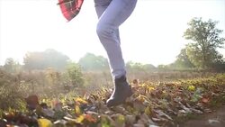 Woman walking through autumn leaves on ground Stock Footage