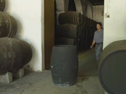 man emerging from wine cellar and rolling away barrel Stock Footage