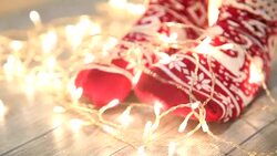 Woman's legs in seasonal winter socks by th Christmas decoration Stock Footage