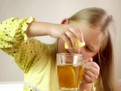 Little girl squeezing lemon, drinking tea. Stock Footage