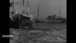1936: NEW ENGLAND: FISHING INDUSTRY: MASSACHUSETTS: Fishing boats ice covered water. Docked Steam trawlers. Steam trawler fishing boat moving out to sea. Instructional Video