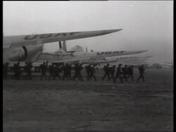 B/W 1950's wide shot of soldiers walking past parked airplanes / Korea / NO SOUND Stock Footage