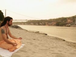 Sage doing padmasana at ganges riverbank, Laxman Jhula, Rishikesh, Uttarakhand, India Stock Footage