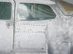 MS PAN aircraft mechanic sanding down airplane stripped back to aluminum hull, RED R3D 4K Stock Footage