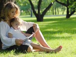 Mother and daughter reading book in park Stock Footage