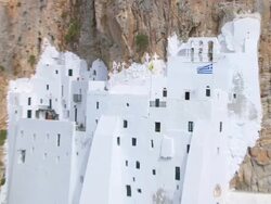WS ZI AERIAL View of man preparing for ringing bell in monastery at wall of rock / Amorgos, Cyclades, Greece Stock Footage