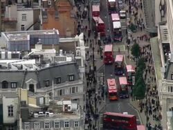 Aerial wide shot crowds and buses on Oxford street / zoom out cityscape / London, England Stock Footage