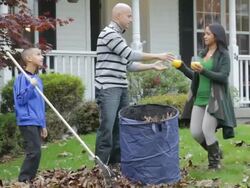 MS TU PAN Father and son raking leaves and mom brings out cold drinks / Albany, New York, United States Stock Footage