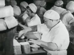 B/W 1934 woman in cap making sandwiches in school lunch kitchen in WPA project / documentary Stock Footage