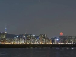 Night scenery of many buildings and Namsan Tower and rising of the moon in the sky from Han River Stock Footage