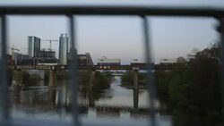 View from Pfluger Pedestrian Bridge as freight train cars cross railroad bridge over Colorado River in Austin, Texas at sunset Stock Footage