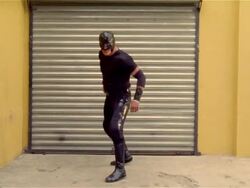 Wide shot luchador 'Shadow' facing garage door/ turning/ zoom in on mask/ Monterrey, Mexico Stock Footage