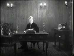 Britain's King Edward VIII sits behind desk. News Clip