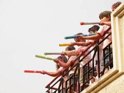 Group of kids playing holi festival on roof top  Stock Footage