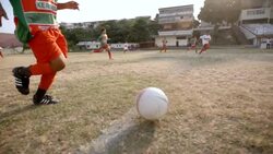 Young Brazilian boy dribbles ball down soccer field in slow motion Stock Footage