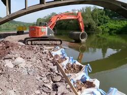 WS Shot of excavator loaded with cement pipe bridge construction site near Saar river / Wiltingen, Rhineland Palatinate, Germany Stock Footage
