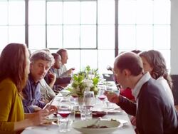 MS group of friends sitting at dinner party in loft eating dinner Stock Footage