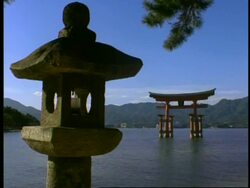 WA view across water to statue and floating gate of the Itsukushishima shrine, Miya-Jima island, Japan Stock Footage