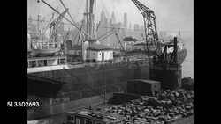 1937: U.S. METAL JUNK YARD: WS Metal junk barge. WS Crane on dock lifting metal scraps onto ship. WS 'Rendino,' Junk Man, w/ three young men unloading bags of metal. CU 'Rendino' going through metal plates w/ bells &amp; pipes. Instructional Video