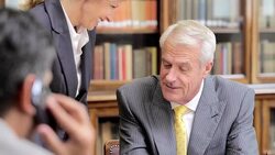 Lawyer talking on cell phone in meeting with colleagues Stock Footage