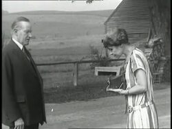 First Lady Grace Coolidge takes a picture of U.S. President Calvin Coolidge, who frowns. News Clip