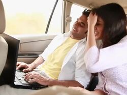 Couple chatting on a laptop in a car  Stock Footage