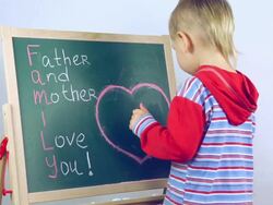 boy draws a card for parents Stock Footage