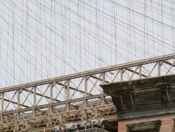 TS TU Top of red apartment building pan and tilt to top of section of Brooklyn Bridge / New York, New York, USA and ZI to high window Stock Footage
