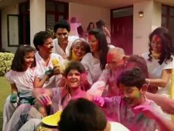 Family celebrating holi festival in the lawn  Stock Footage