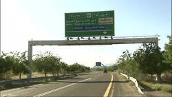 An SUV travels under a traffic sign on a highway. Stock Footage
