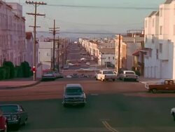 POV driving up hilly city street Stock Footage