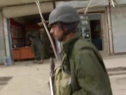MS POV PAN Soldiers walking on street / Musa Qala, Helmand Province, Afghanistan. Stock Footage
