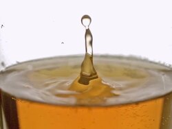 CU SLO MO Drop of Beer falling into glass / vieux pont en auge, Normandy Stock Footage