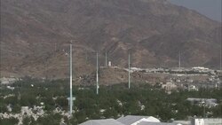 Tall antennas dot a forested valley near a transformer on a hill. Stock Footage