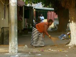 MS Shot of women cleaning outside of house / Conakry, Guinea Stock Footage