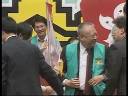 HONG KONG: CHIEF EXECUTIVE FALLS OFF PODIUM DURING VOTER CAMPAIGN News Clip