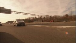 The hazard lights flash on an unmarked police car on the side of a freeway. Stock Footage